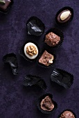 An assortment of filled chocolates and empty chocolate cases