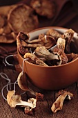 Dried porcini mushrooms in a bowl on a wooden surface