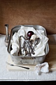 Muslin cloth, kitchen utensils and plums in a roasting tin