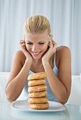 A blonde woman looking at a stack of doughnuts