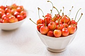 Two white bowl of fresh cherries