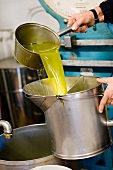 Frisch gepresstes Olivenöl wird umgeschüttet