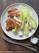 Sliced Chicken Breast with Caesar Salad on a White Plate; From Above