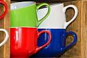 Assorted colours of mugs in a shelf compartment