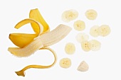 A half-peeled banana and slices of banana