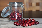Cranberries in and in front of a preserving jar