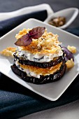 An aubergine tower with aubergine cream cheese and Parmesan chips
