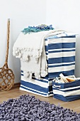 Blue and white laundry basket with lid and small storage basket with rug in foreground