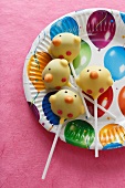Cake pops (chicks) on a colourful paper plate