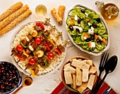 Grilled skewers of lamb on rice, with salad, pita bread and olives (Greece)