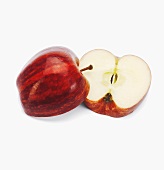A Braeburn apple, halved, against a white background