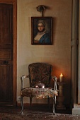 Antique portrait of woman above Rococo chair with worn fabric upholstery