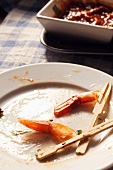 Shrimp Tail Remains with Toothpicks on a Dirty Plate