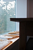 Animal skin cushions on bench in front of window element with fixed glass panel