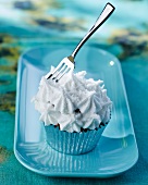 A cupcake topped with white icing