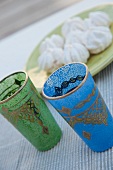 Farbige Teegläser mit orientalischem Muster neben Schale mit Süssigkeiten
