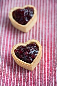 Heart-shaped biscuits filled with cranberry jam
