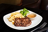 Beef steak with chips and sauce