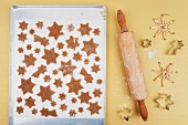 Christmas biscuits on a baking tray next to a rolling pin and cutters