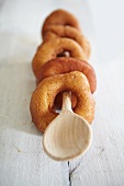 Several ring doughnuts on a wooden spoon