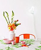 Dining area in cheerful colours with bright orange, retro chair and amusing, heart-shaped lamp