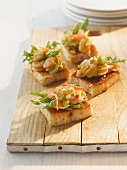 Bruschetta topped with asparagus on a chopping board