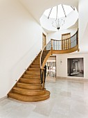 Skylight above curved wooden staircase in large foyer
