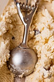 An ice-cream scoop forming a scoop of home-made stracciatella ice cream