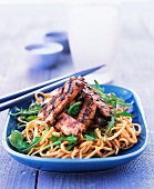 Pork with soy and garlic on a bed of noodles (Asia)