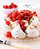 Pavlova Topped with Whipped Cream, Raspberries and Powdered Sugar