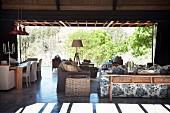 Living room terrace with floral sofa, rattan side table and dining table in background