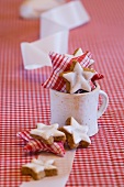 Star-shaped cinnamon biscuits and fabric stars in a mug