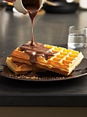 Nougat sauce being poured over waffles