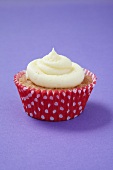 A cupcake in a red and white polka-dot paper case