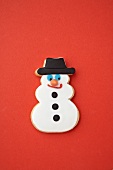 A snowman biscuit on a red surface