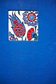 Floral mosaic tile on blue wall