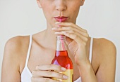 Woman drinking soda through straw