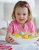 Young girl holding bowl of Easter eggs