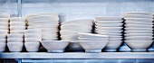 Gestapelte Teller und Schüsseln auf einem Küchenregal