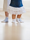 Füße von Mutter und Kind beim Laufen lernen
