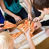 Freunde essen Pizza aus dem Katon