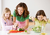 Mutter und Töchter bereiten den Salat gemeinsam zu