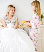 Daughter bringing mother breakfast in bed