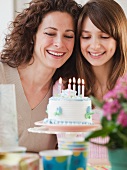 Girl (10-12 years) celebrating birthday with mother