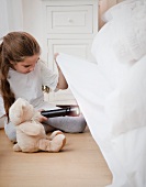 Young girl looking under bed