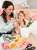 Mother and daughter making flower arrangement