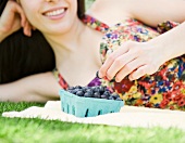 Young woman eating blueberries