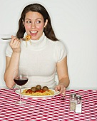 Portrait of woman eating spaghetti with meatballs
