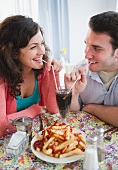 Paar geniesst Cola und Pommes frites mit Ketchup