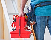 Close up of construction worker carrying tool box